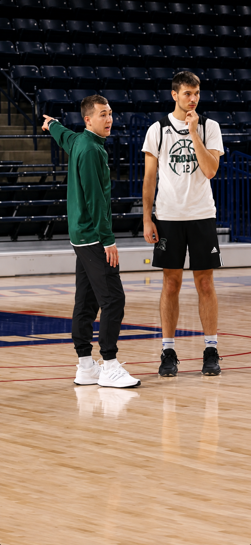 Coach Zach Grant instructing a Mount Olive Trojan player on the court